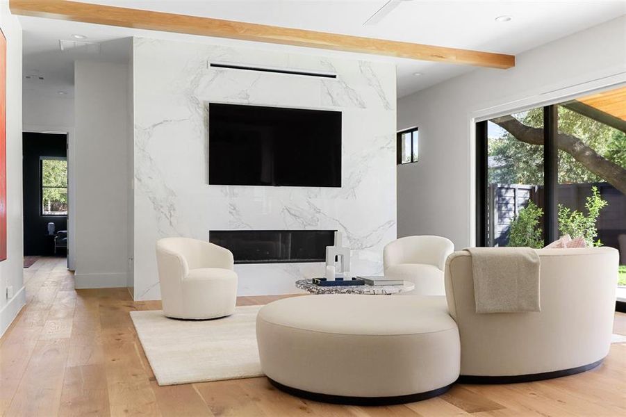 Living room with hardwood / wood-style flooring, a premium fireplace, and beam ceiling