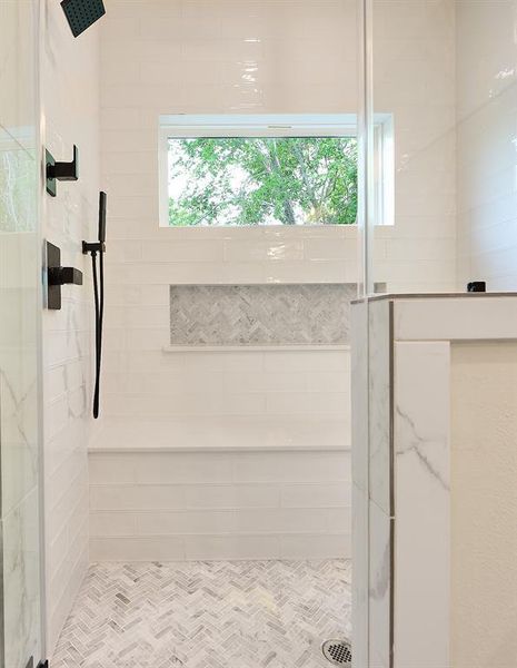 Functional and aesthetic shower features a tiled out bench with massive built in shower caddy.