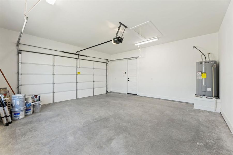 Garage featuring a garage door opener and water heater