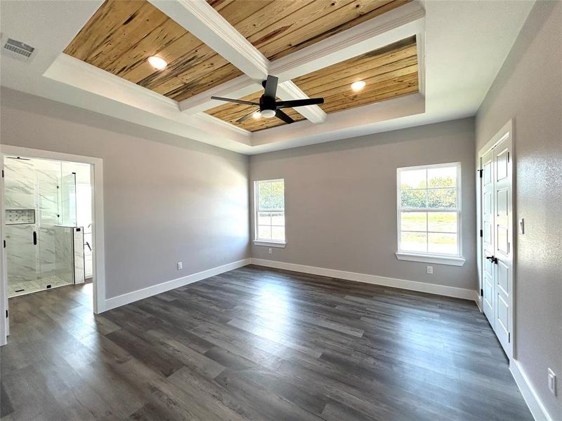 Spare room featuring ceiling fan, a tray ceiling, dark hardwood / wood-style floors, and wooden ceiling