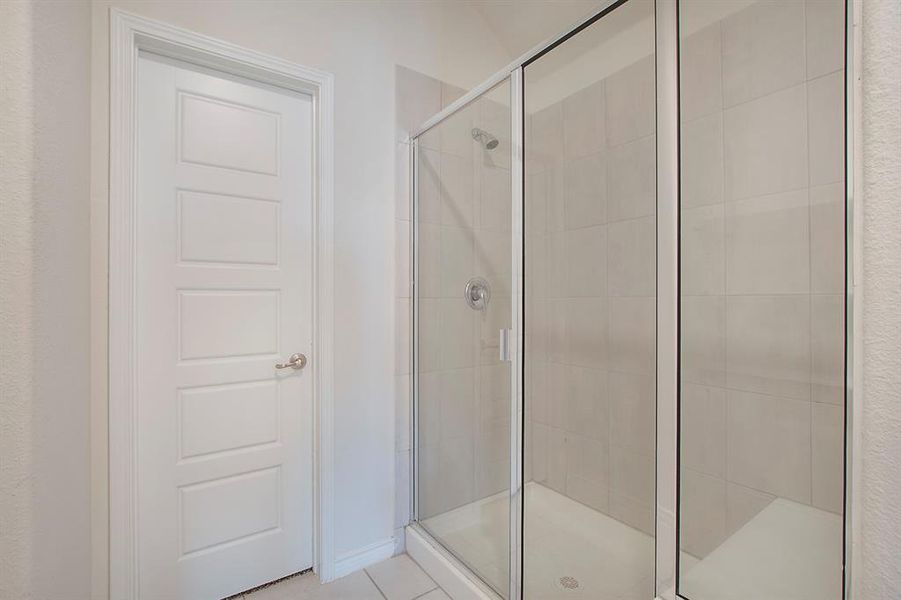 Bathroom featuring walk in shower and tile patterned flooring