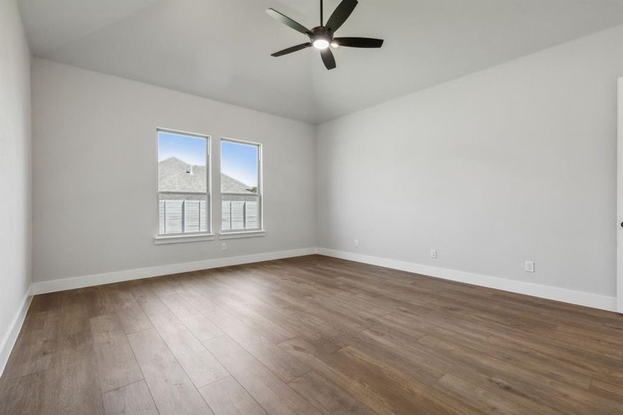 Unfurnished room featuring ceiling fan, hardwood / wood-style flooring, and vaulted ceiling