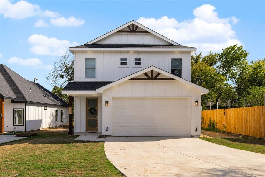 View of front of property with a garage and a front yard