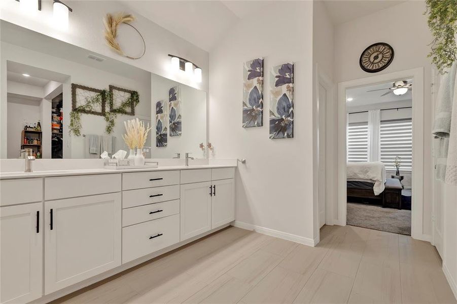 Elegant Bathroom Design - Shows the door leading into the primary suite, highlighting dual sinks and luxurious finishes.