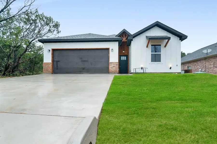 View of front of house featuring a garage and a front yard