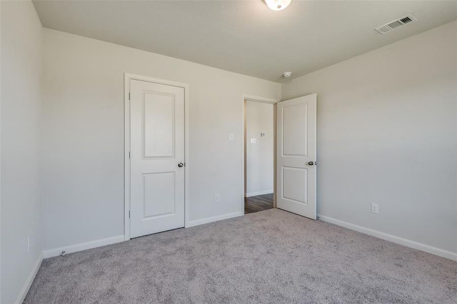 Unfurnished bedroom with light colored carpet