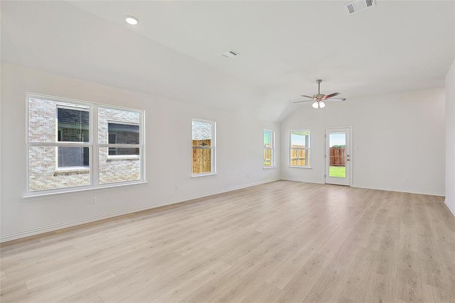 Spare room featuring vaulted ceiling, ceiling fan, and light hardwood / wood-style floors