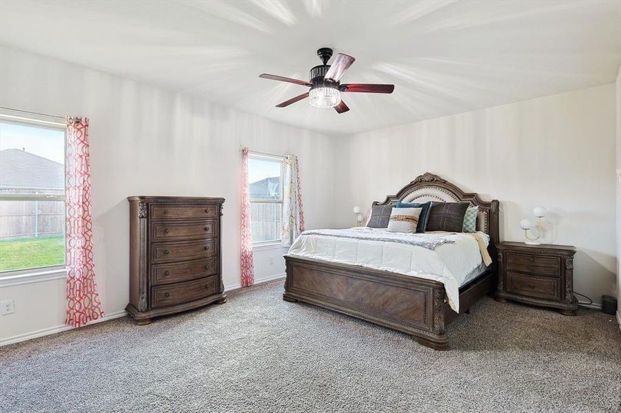 Carpeted bedroom featuring ceiling fan