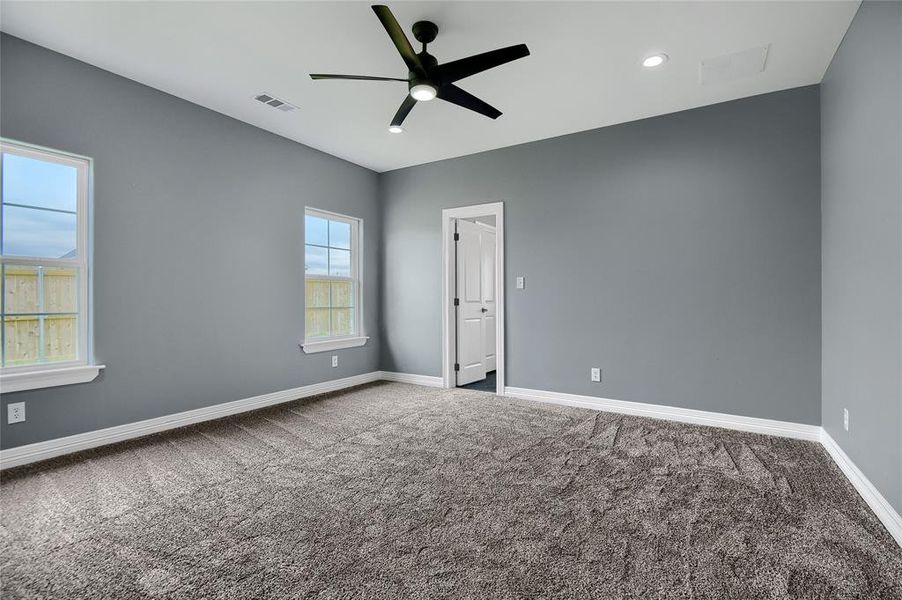 Carpeted spare room featuring ceiling fan