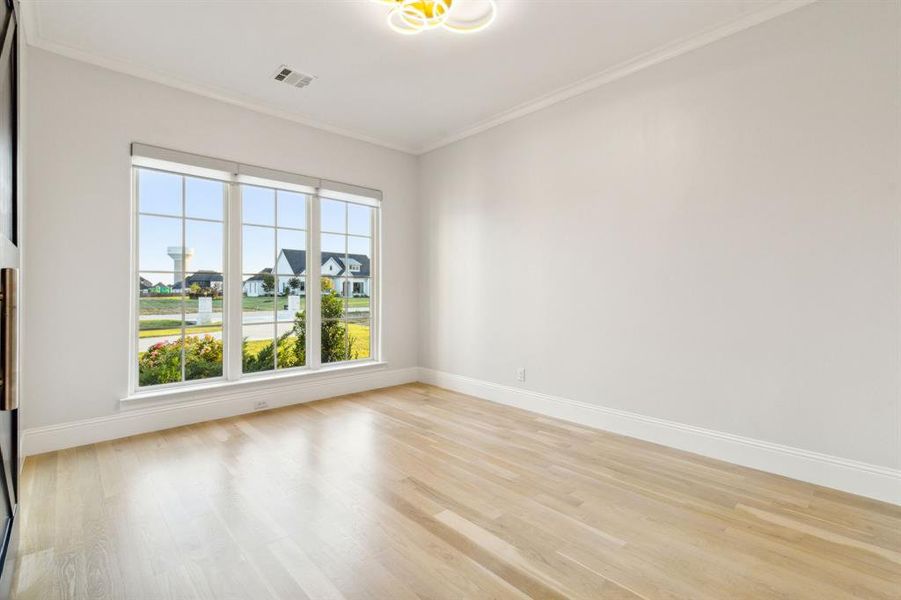 Formal living room has barn doors and is flexible space that could be used as another office or flex space