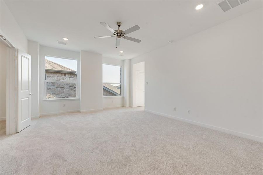 Carpeted spare room featuring ceiling fan