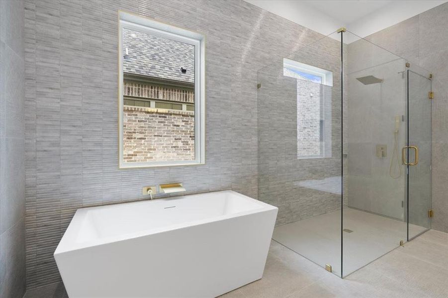 Bathroom featuring separate shower and tub, tile walls, tile patterned floors, and a wealth of natural light