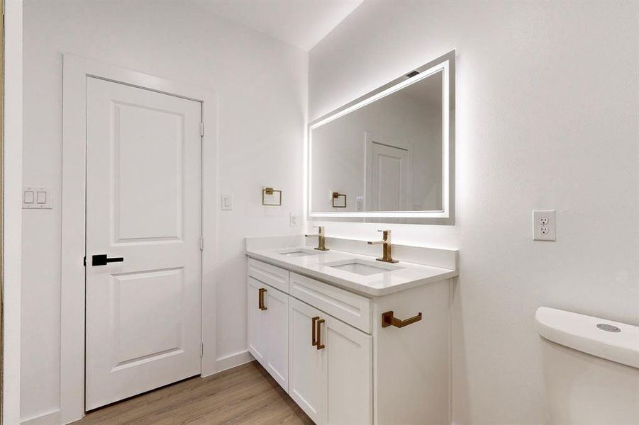 Bathroom featuring hardwood / wood-style flooring, vanity, and toilet