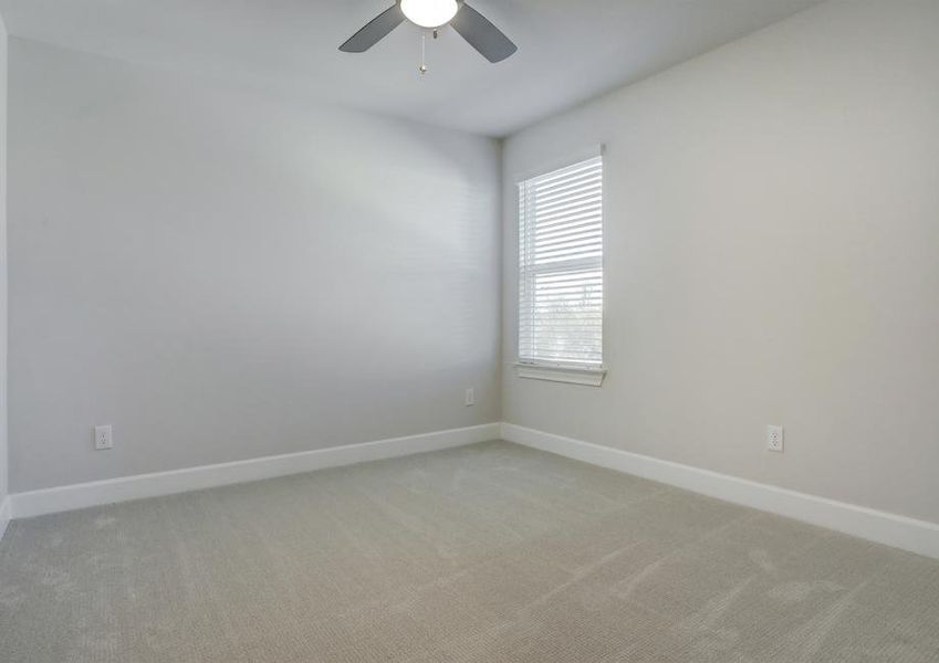 Guest bedroom with a window, ceiling fan, and light-colored carpet.