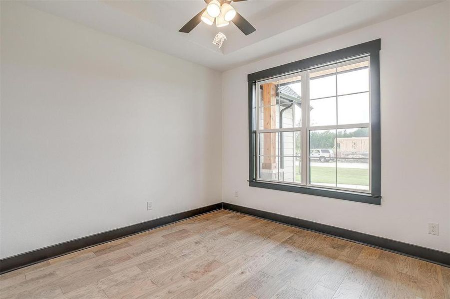 Empty room with light hardwood / wood-style floors and ceiling fan