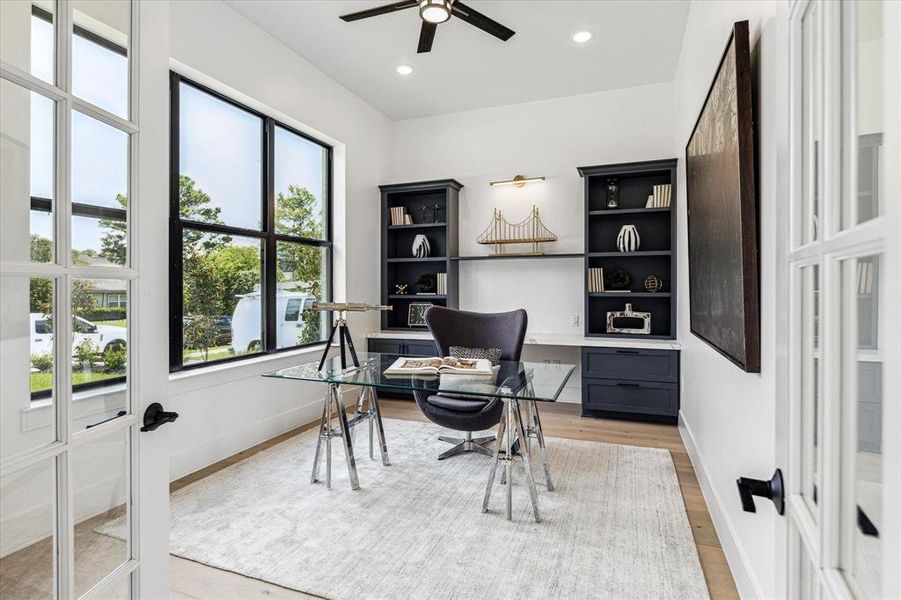 Imagine working from home here! This bright and airy office, located near the front of the home, is perfect for productivity with its large windows and custom built-ins.