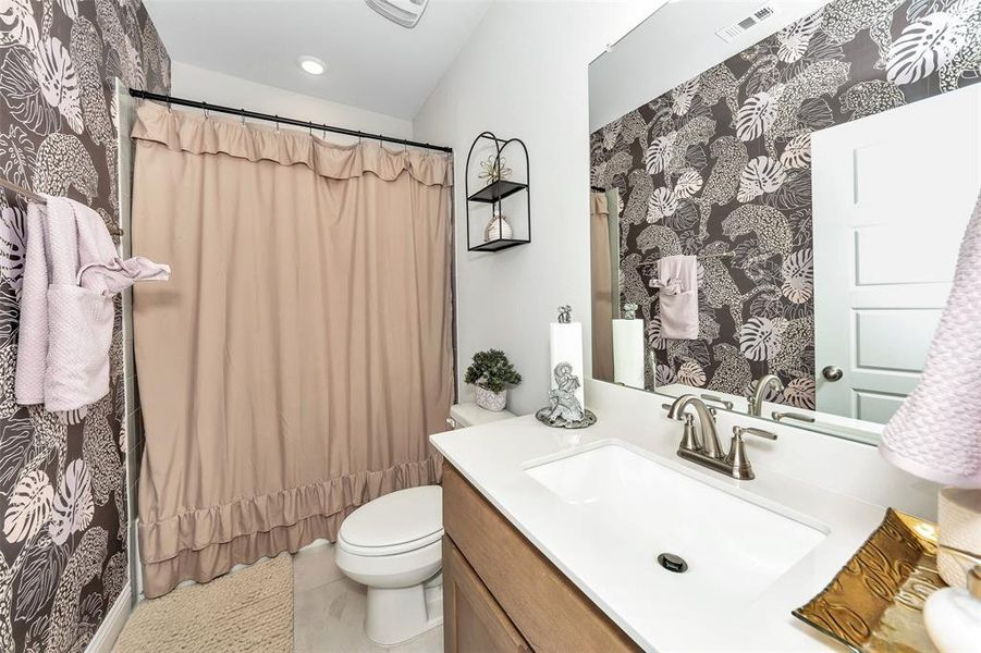 Bathroom featuring vanity, toilet, a shower with shower curtain, and tile patterned flooring