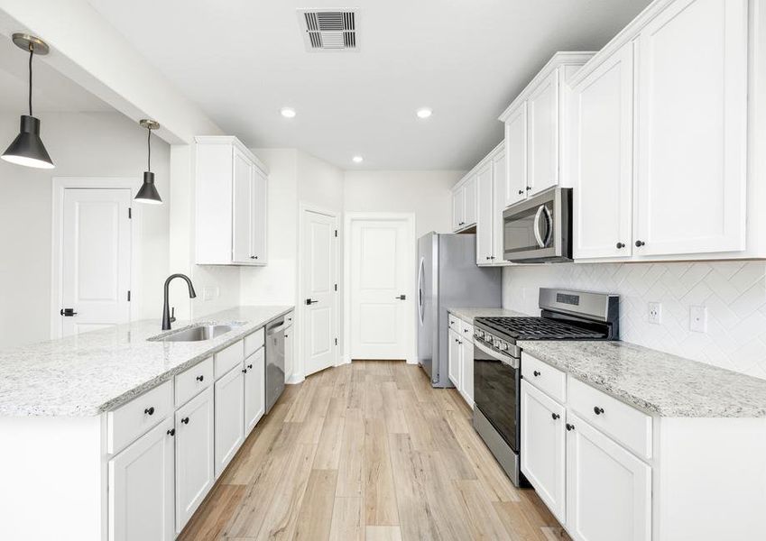 The fully loaded kitchen has granite countertops and white cabinets.
