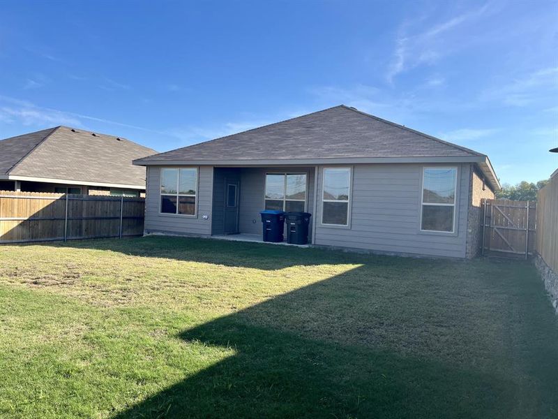 Rear view of property with a yard