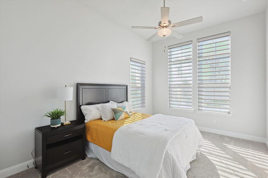 Carpeted bedroom featuring ceiling fan