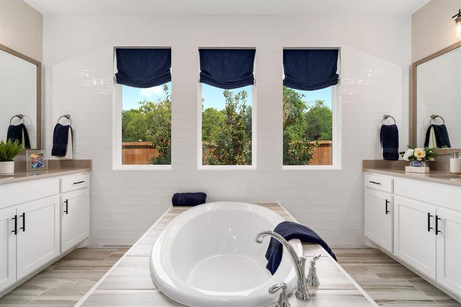 Bathroom featuring vanity, a bath, and hardwood / wood-style floors