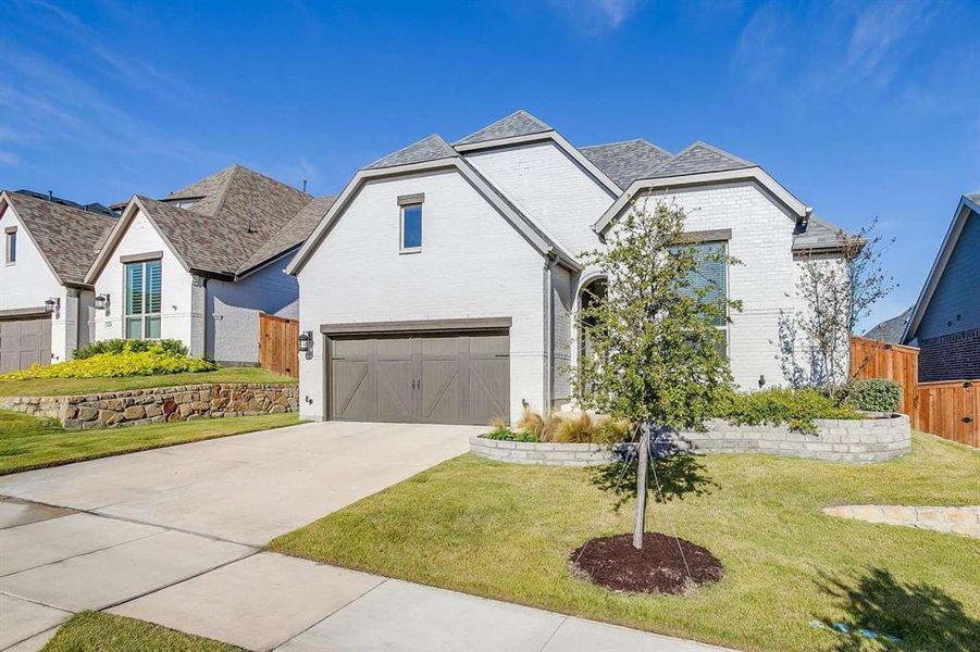 View of front of home featuring a garage and a front lawn