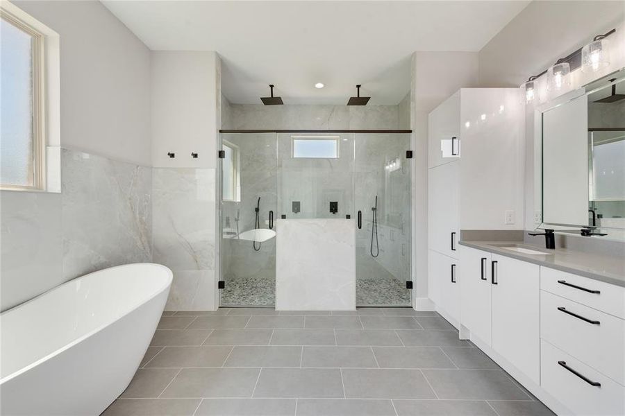 Bathroom featuring independent shower and bath, vanity, tile walls, and tile patterned floors