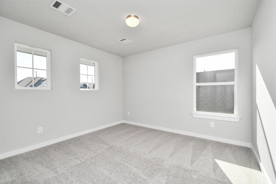 Generously sized secondary bedrooms featuring spacious closets, soft and inviting carpeting underfoot, large windows allowing plenty of natural light, and the added touch of privacy blinds for your personal retreat. Sample photo of completed home with similar floor plan. As-built interior colors and selections may vary.