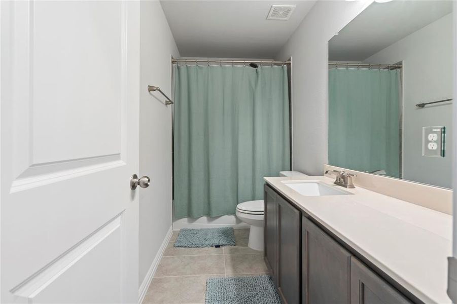 Bathroom featuring tile patterned flooring, vanity, and toilet