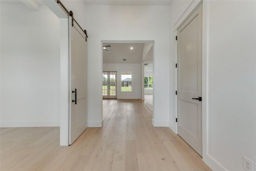 Hall with light hardwood / wood-style flooring and a barn door