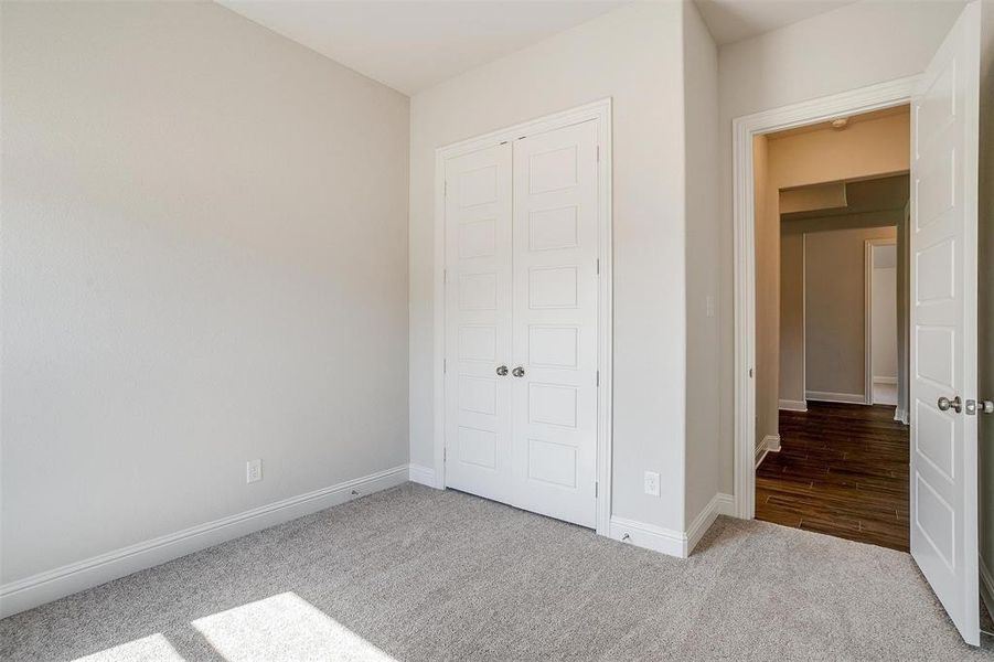 Unfurnished bedroom with light carpet and a closet