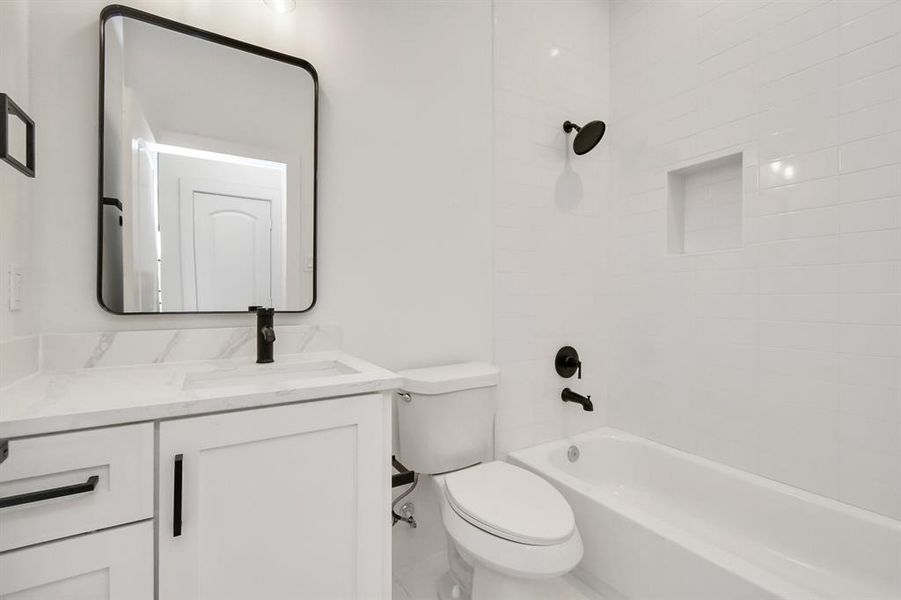 The full bathroom offers crisp white tile flooring, a stylish white vanity, and a luxurious quartz countertop. Enjoy the convenience of a shower-tub combo, perfect for both quick showers and relaxing baths.