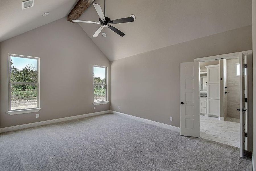 Spare room featuring high vaulted ceiling, beamed ceiling, light carpet, and ceiling fan