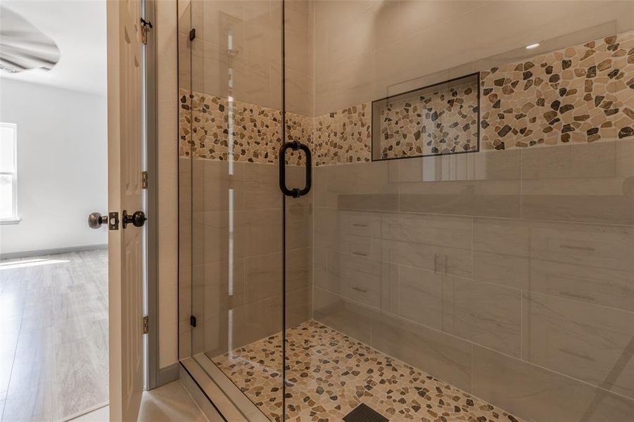 Bathroom with wood-type flooring and a shower with door