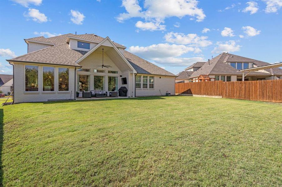 Rear view of house with a patio, a lawn, and ceiling fan