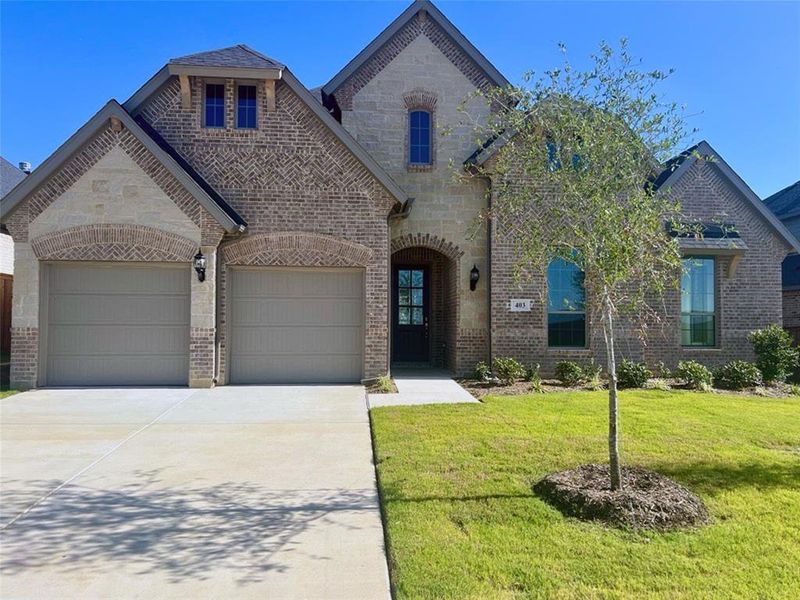 French country style house with a garage and a front lawn