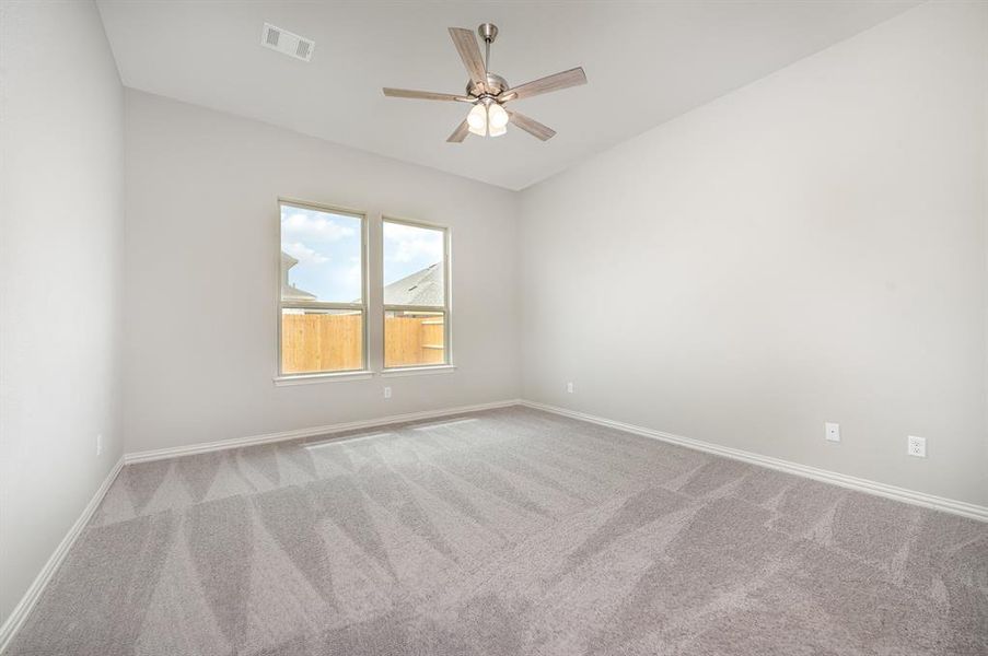 Carpeted empty room featuring ceiling fan