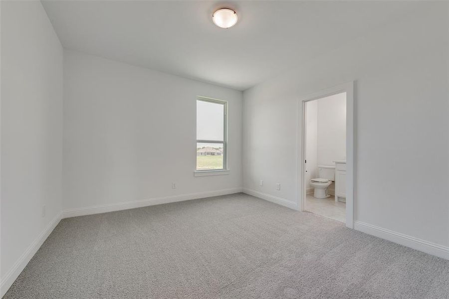 Unfurnished bedroom featuring carpet floors and ensuite bath