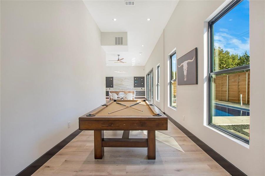 Game room with light hardwood / wood-style floors and pool table