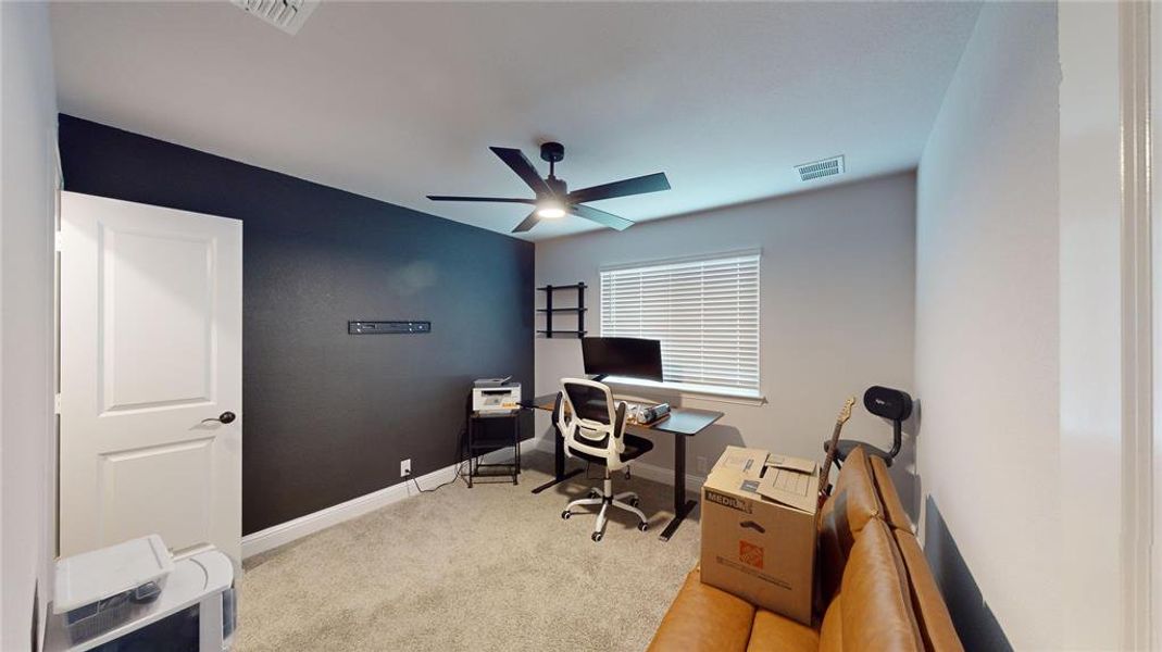 Carpeted office space with ceiling fan