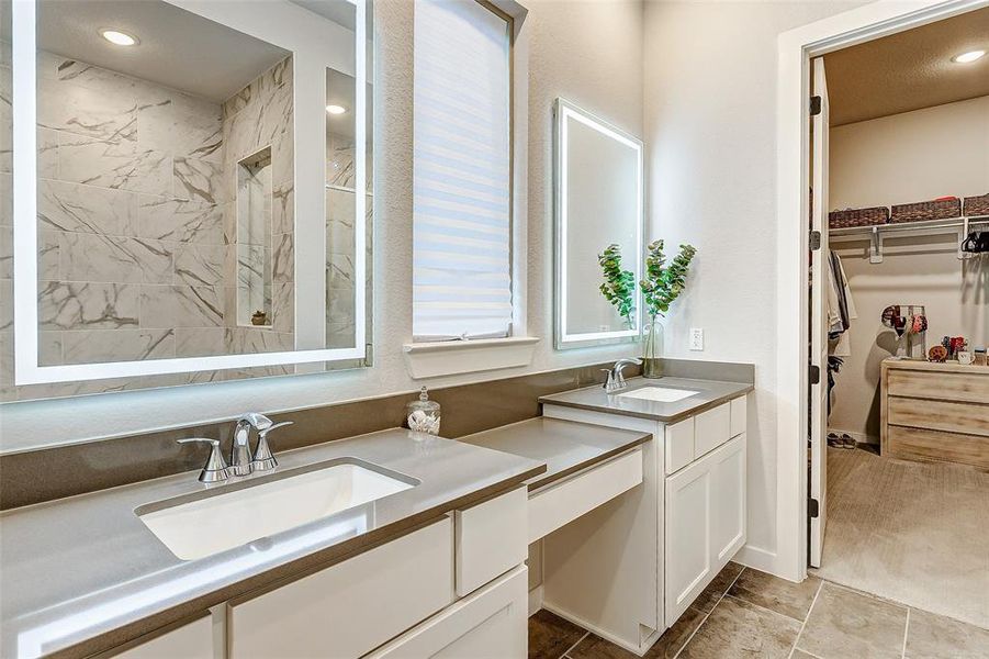 The ensuite primary bath offers custom lit mirrors and a vanity area for the perfect glow for your get ready routine.