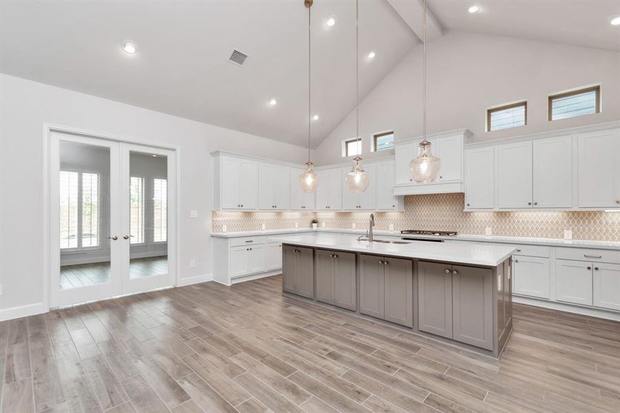 You'll love making meals in this kitchen with an oversized quartz island, 42" white shaker cabinets, under-mount lightning, 5-burner gas stove, double ovens.