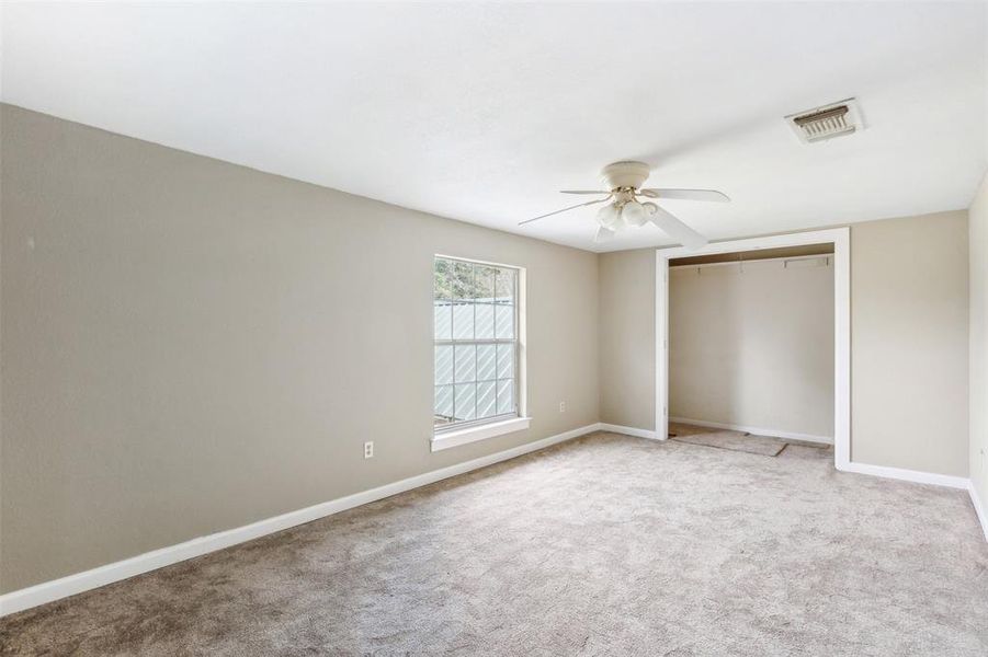 Another upstairs bedroom featuring light carpet, ceiling fan, and a closet