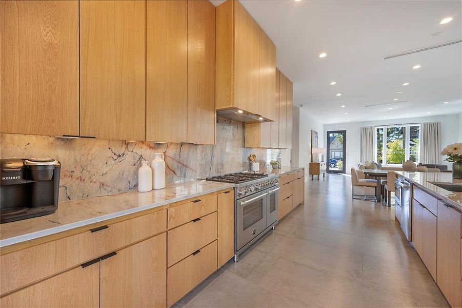 Kitchen with light brown cabinetry, tasteful backsplash, appliances with stainless steel finishes, and sink