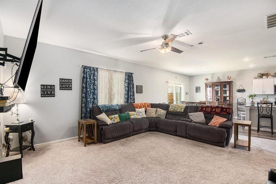 Living room featuring light carpet and ceiling fan