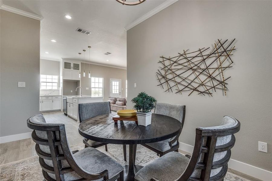 Dining space featuring crown molding, and light hardwood / wood-style floors