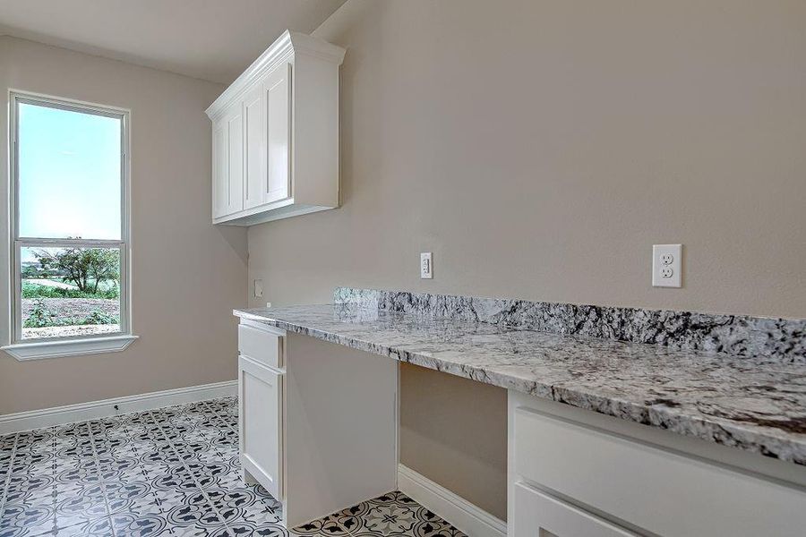 Laundry area with light tile patterned floors