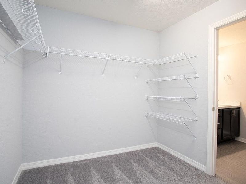 Walk-in wardrobe in your owner`s suite - Photo showcases a home with similar finishes. Colors and design options in actual home for sale may differ.