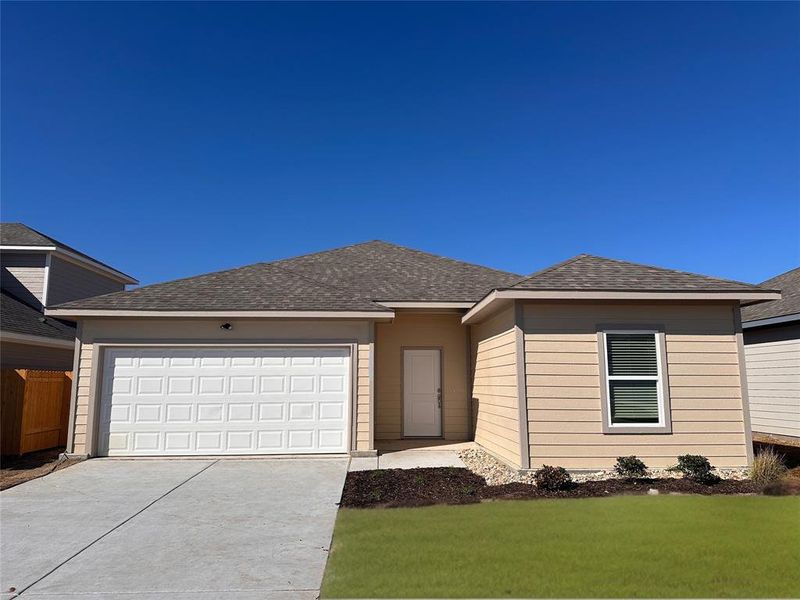 View of front of home featuring a garage and a front yard