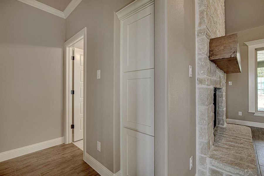 Corridor featuring wood-type flooring and ornamental molding